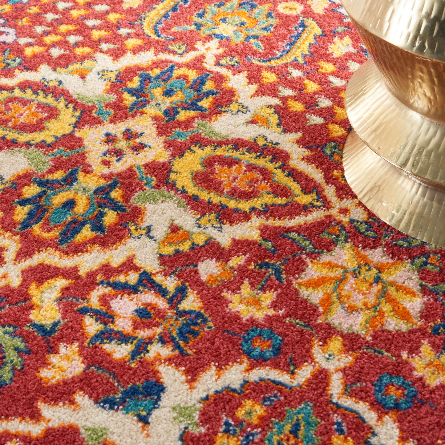 Red oriental floral rug with blue, yellow and green accents in a plush pile.