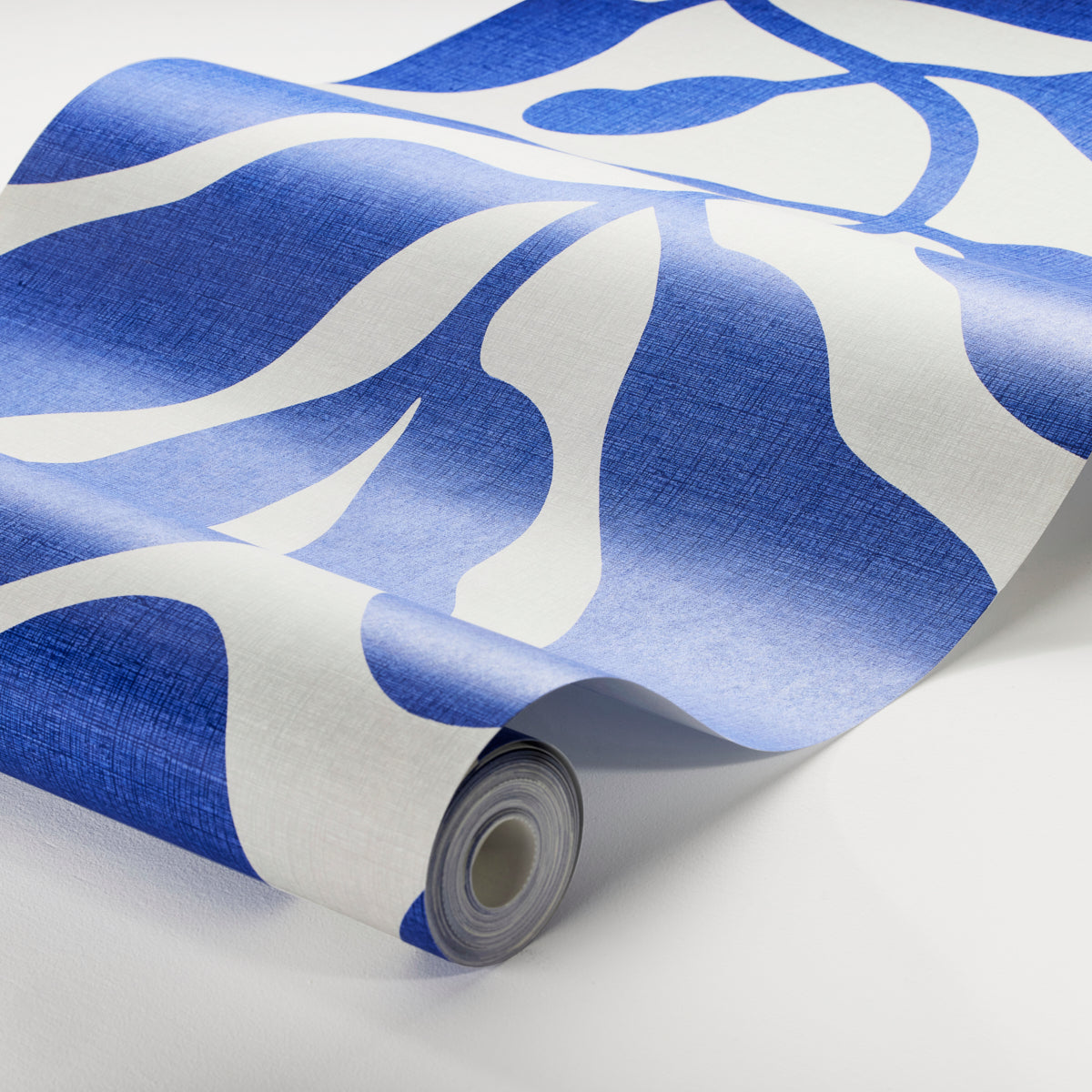 Roll of abstract blue & white wallpaper with large wavy shapes; modern wall decor.
