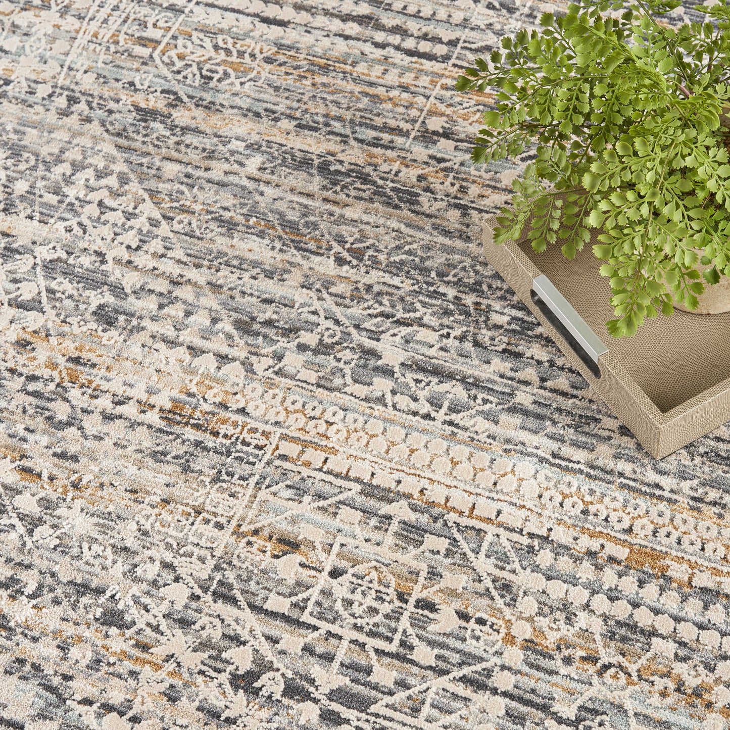 Distressed patterned round area rug in gray, beige and blue tones.