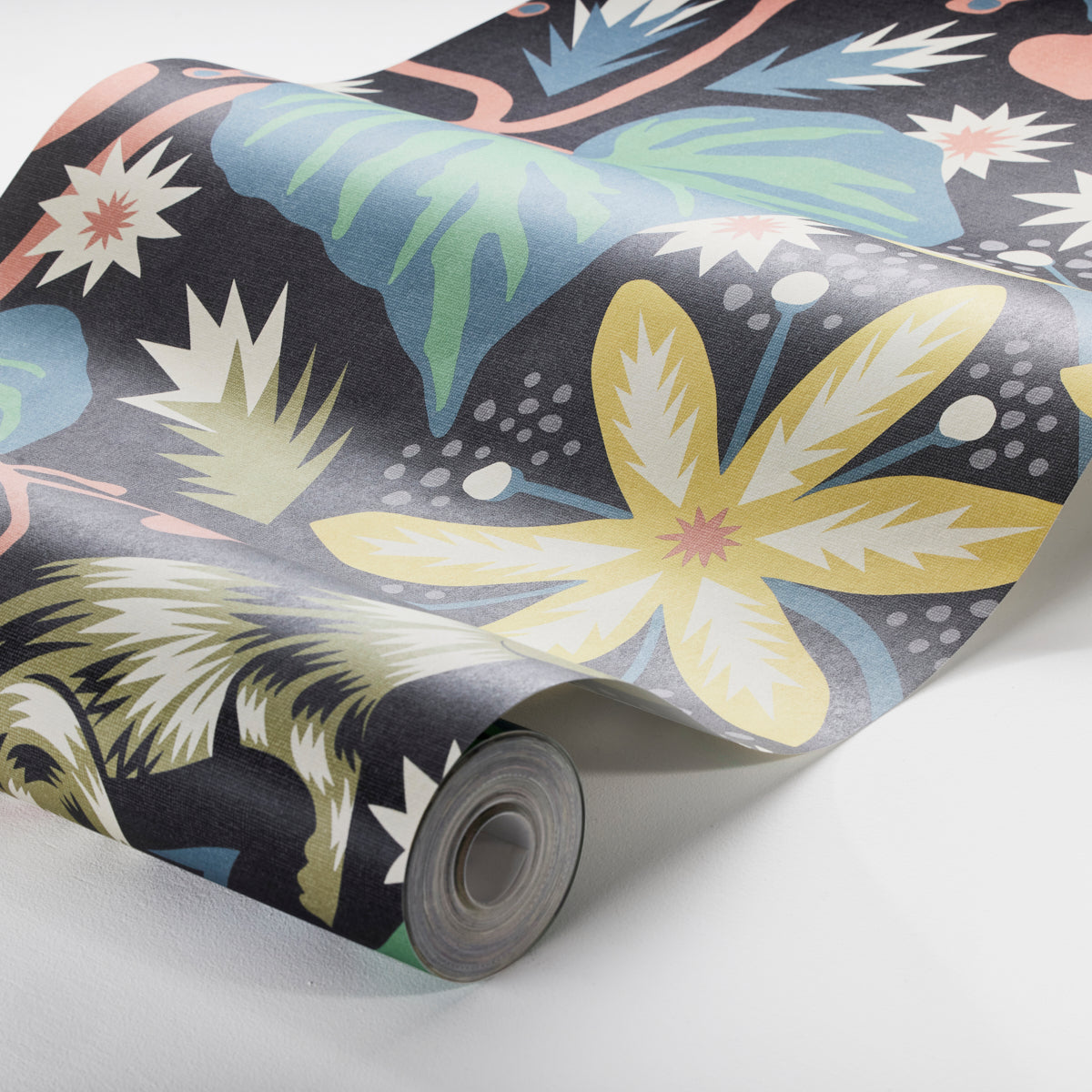 Rolled wallpaper with tropical floral print on dark navy; large yellow flower and blue leaves.