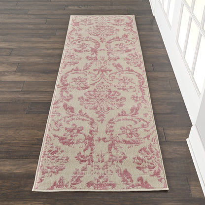 Beige hallway runner rug with pink damask pattern on dark wood floor.