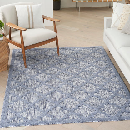Blue-gray woven area rug with a subtle diamond lattice pattern in a modern living room.