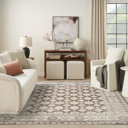 Neutral living room with cream sofa, beige armchair, wooden console, two woven ottomans, and a patterned beige rug.