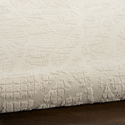 Cream textured area rug with raised geometric patterns and plush pile on dark wood floor.