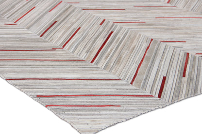 Natural hide indoor hand-stitched rug in light gray with thin red stripes forming chevron blocks; textured modern floor decor.