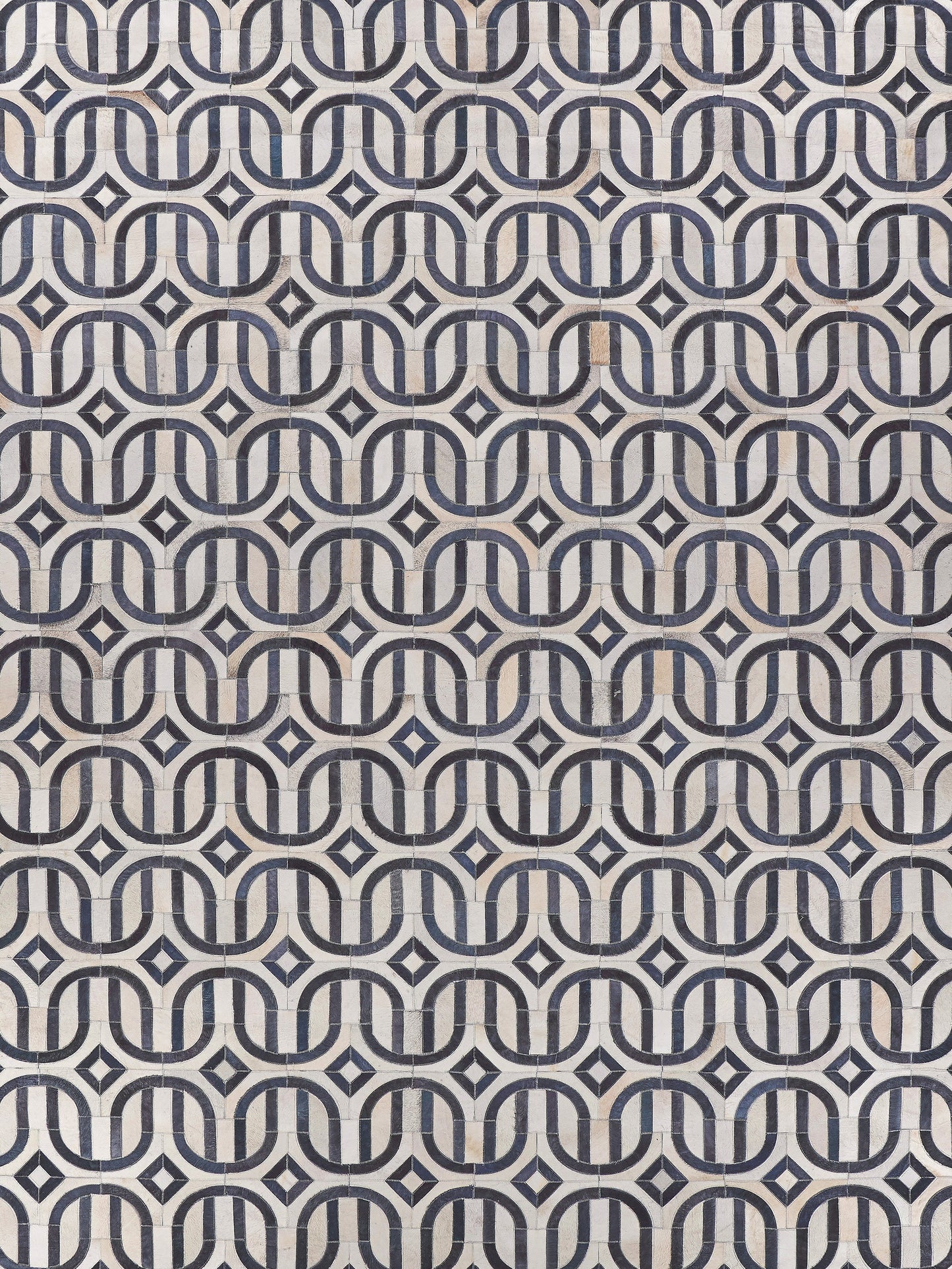 Natural hide rug with hand-stitched detailing; warm neutral tones and visible hide texture.
