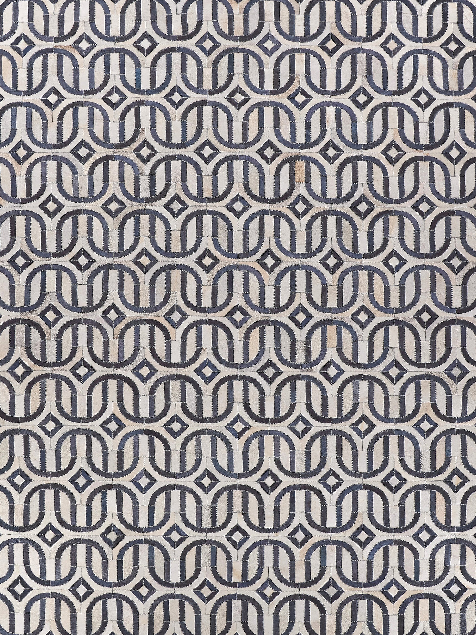 Natural hide rug with hand-stitched detailing; warm neutral tones and visible hide texture.