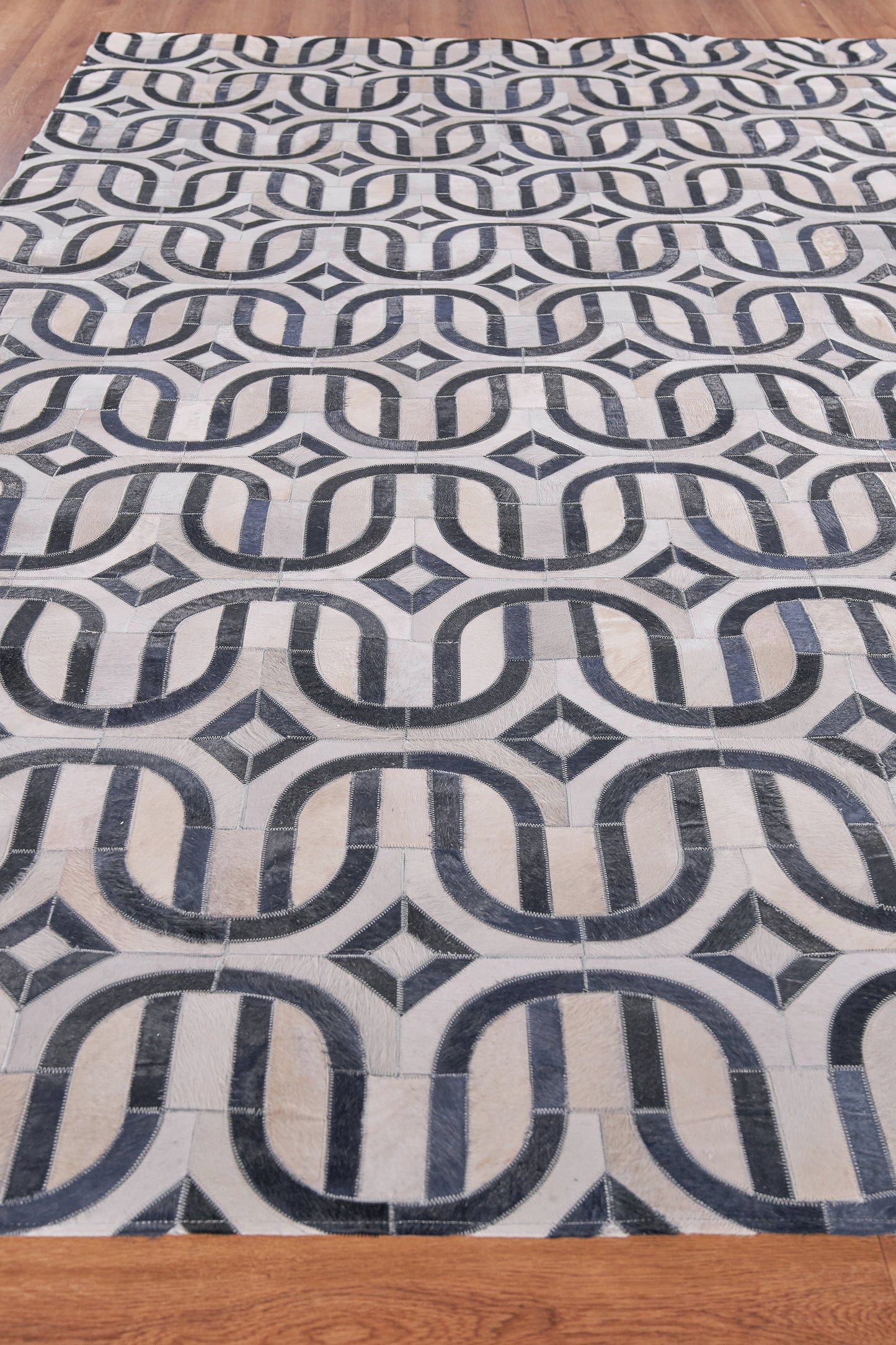 Natural hide indoor hand-stitched rug; rectangular area rug.