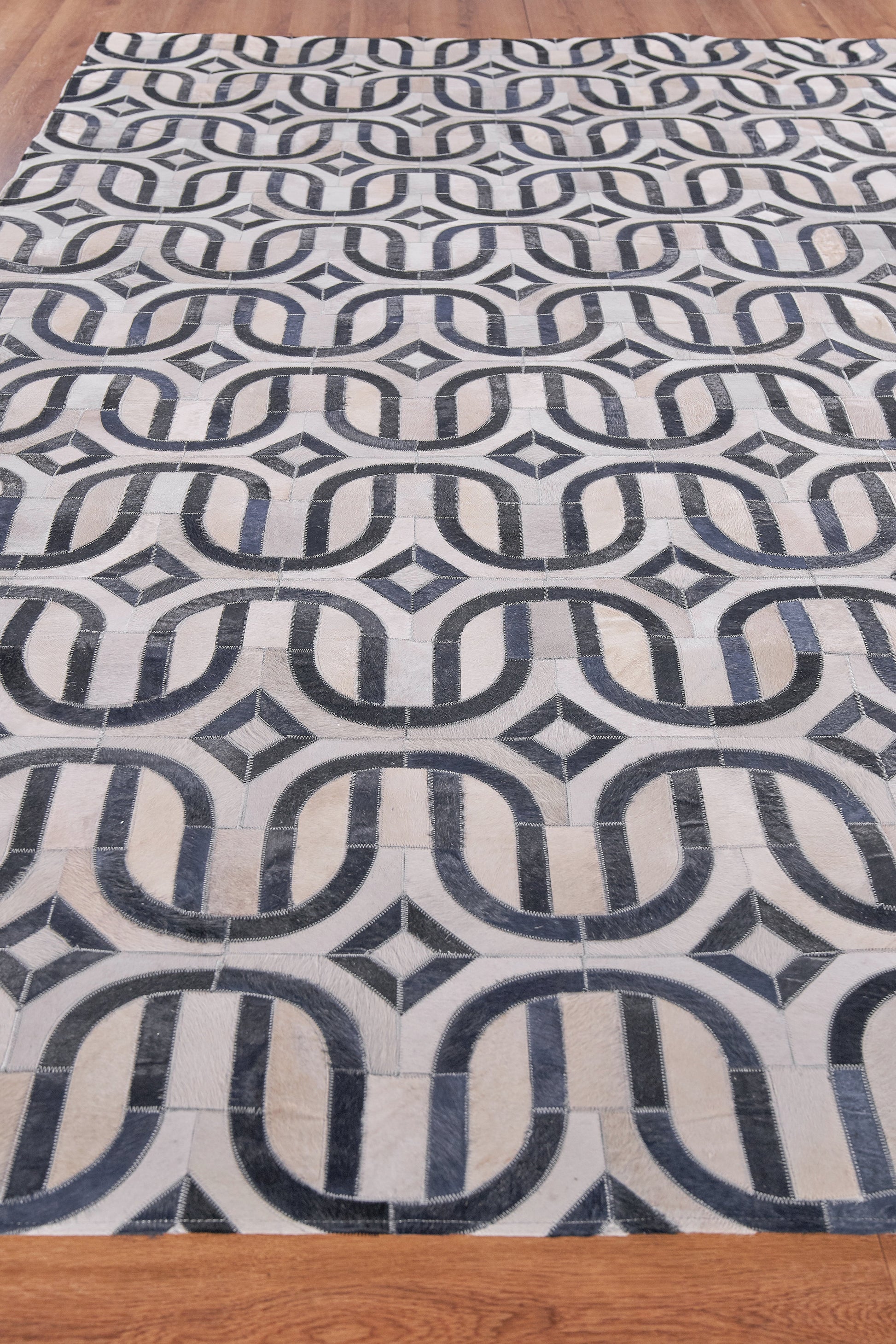 Natural hide indoor hand-stitched rug; rectangular area rug.