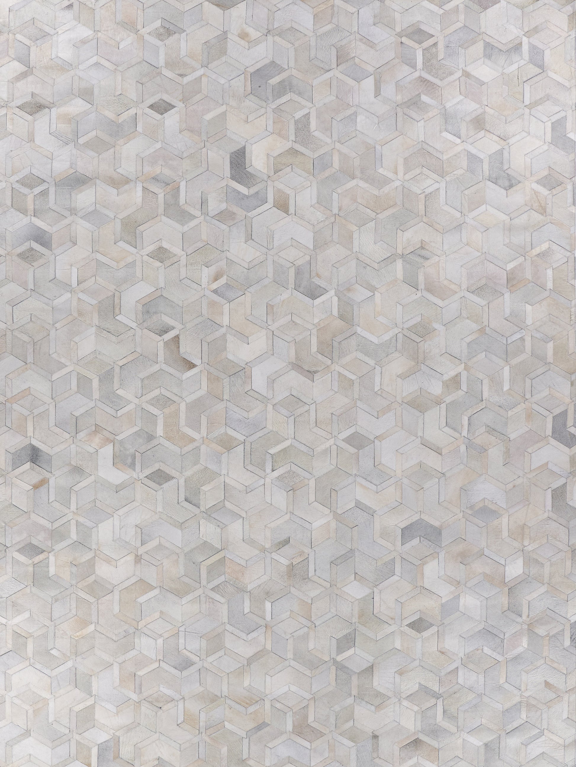 Natural hide indoor rug, hand stitched, in neutral beige, taupe and gray tones, size 5' x 8'.