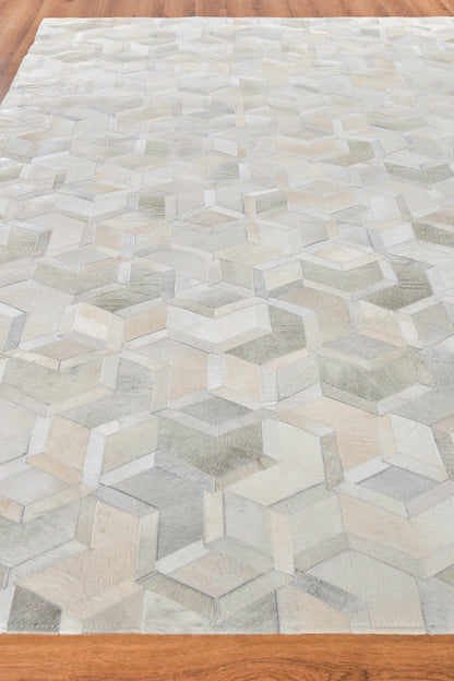 Neutral-toned rug with a 3D cube illusion pattern in ivory, beige & gray on wood floor.