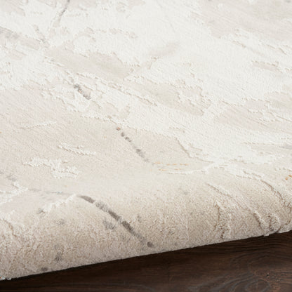 Cream & ivory patterned area rug with raised floral motifs on dark wood floor.