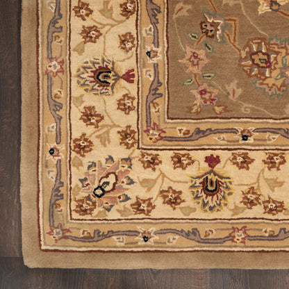 Traditional oriental wool rug with cream and beige border and floral motifs in brown, gold, and blue on dark wood floor.