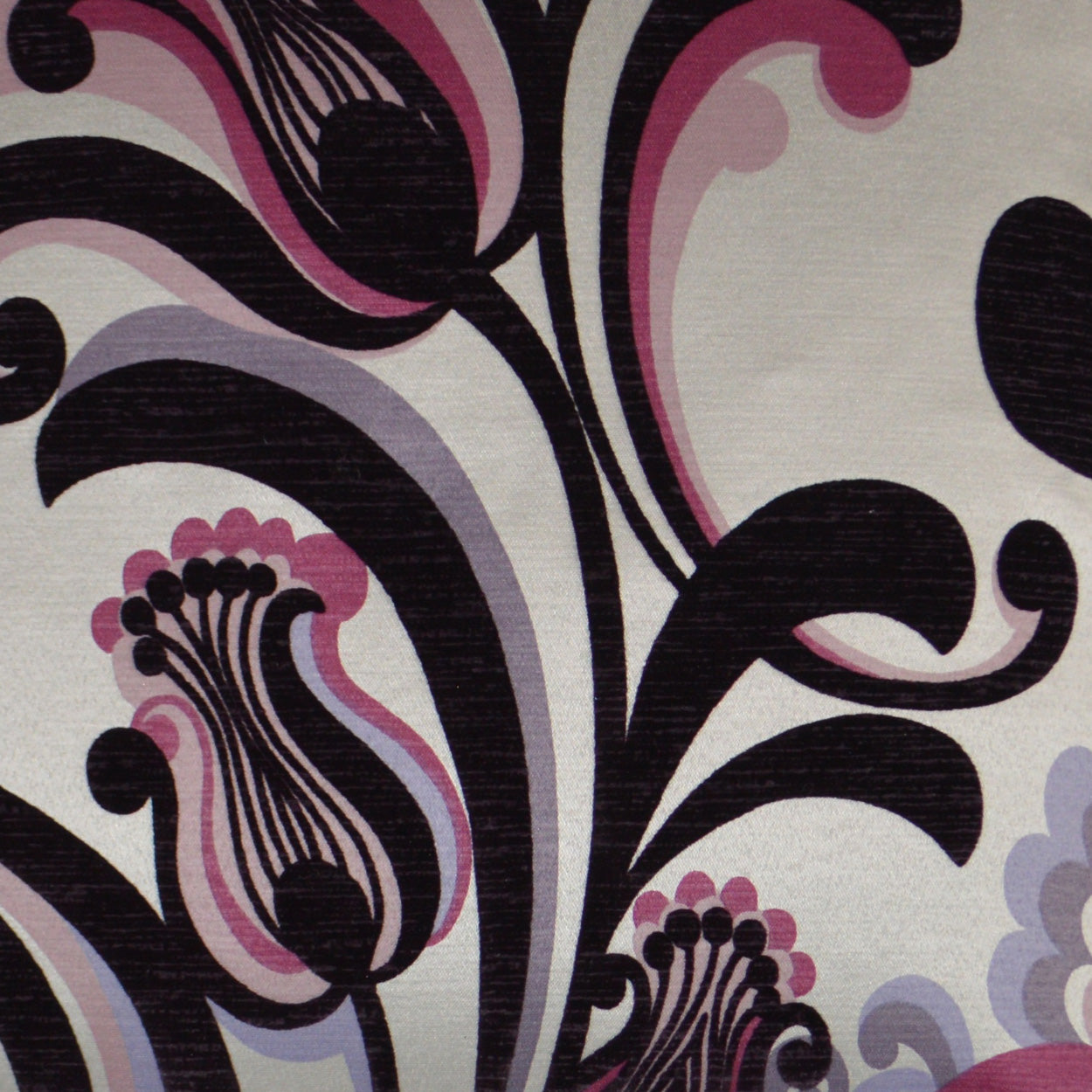 Fabric with bold black scrolling floral motif in pink, purple and lavender on a pale beige background.