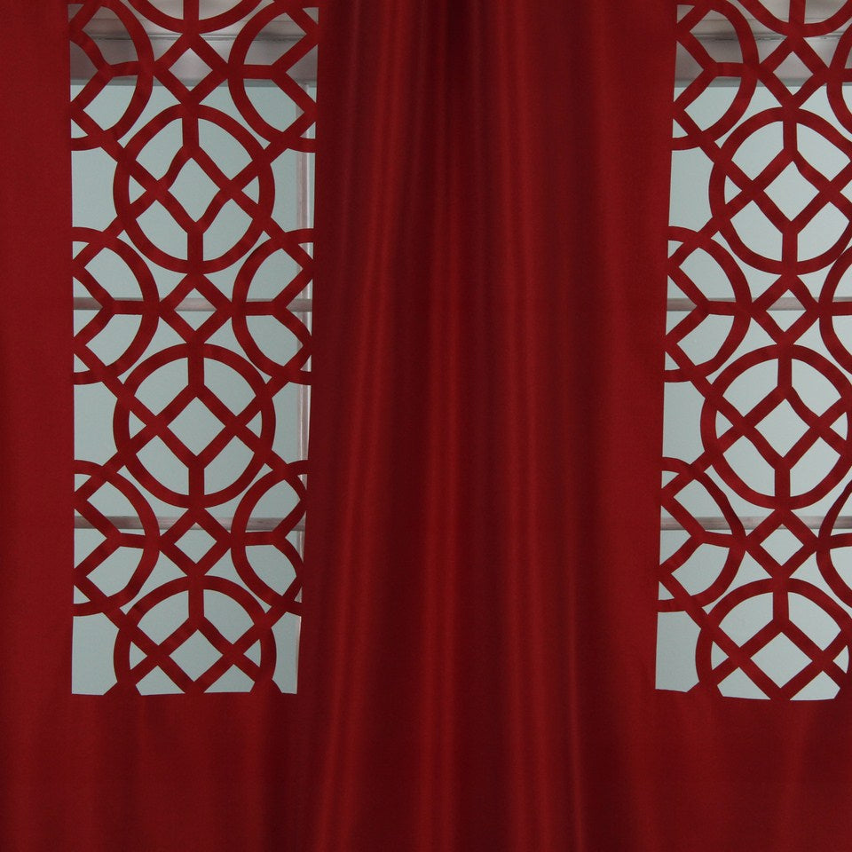 Scarlet drapery panels flanking white circular lattice panels with geometric cutouts.