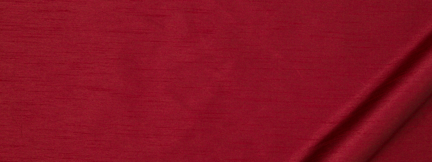 Rich red fabric texture with subtle horizontal weave and a soft diagonal fold along the bottom-right.