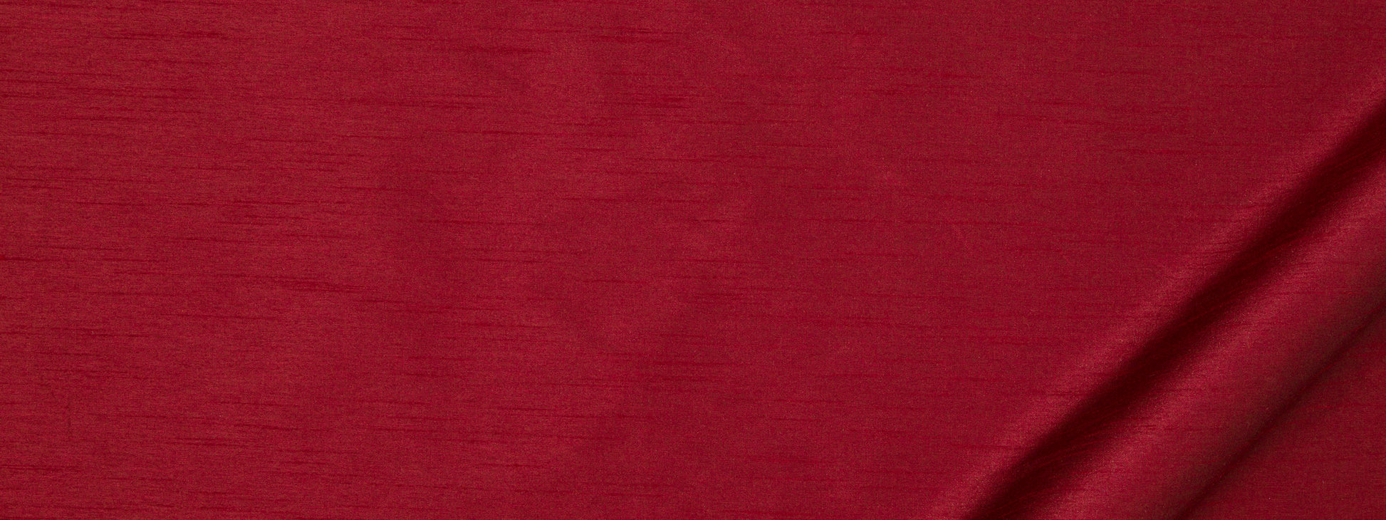 Rich red fabric texture with subtle horizontal weave and a soft diagonal fold along the bottom-right.