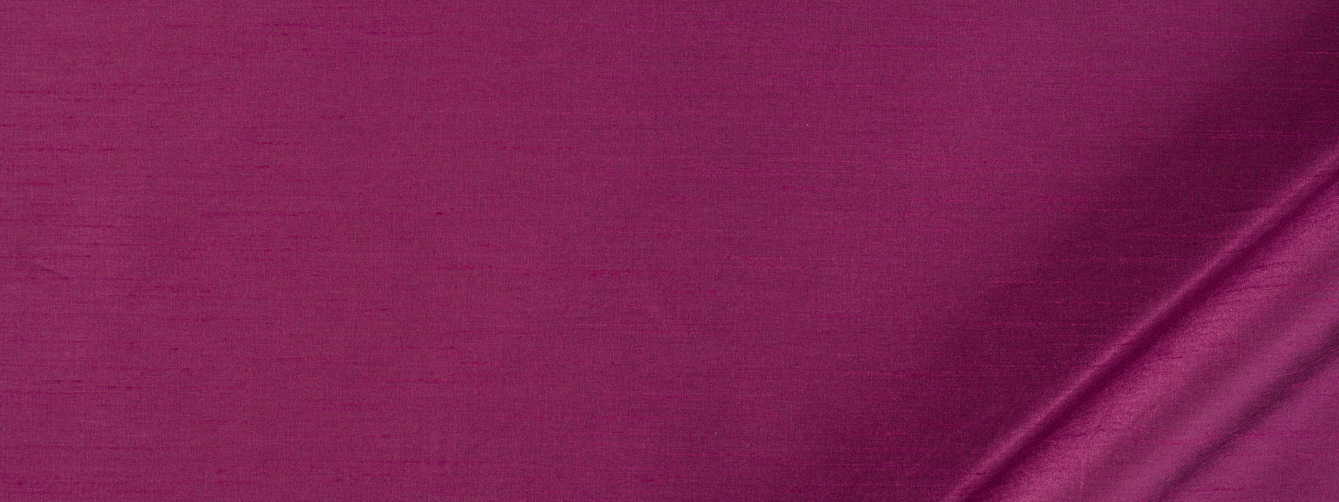 Magenta satin fabric with glossy sheen and soft draped fold, luxurious textile.
