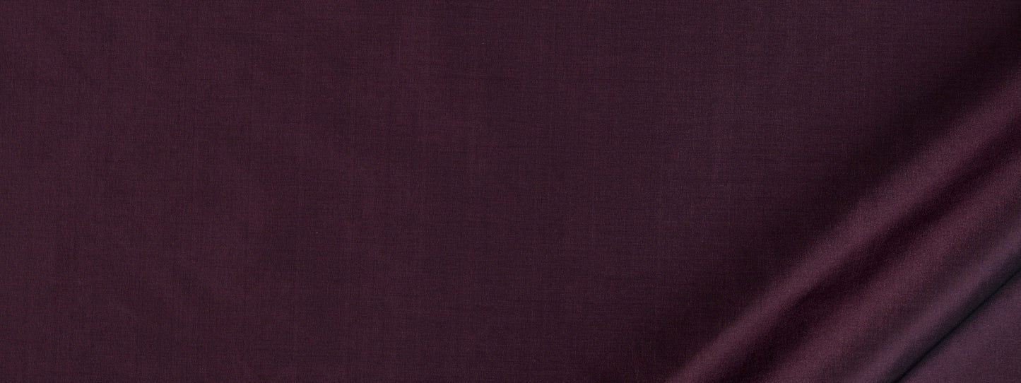 Deep aubergine fabric close-up with soft folds and subtle sheen.