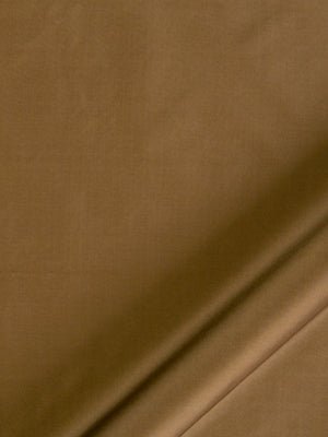 Close-up of tan brown suede-like fabric with a diagonal seam and folded edge.
