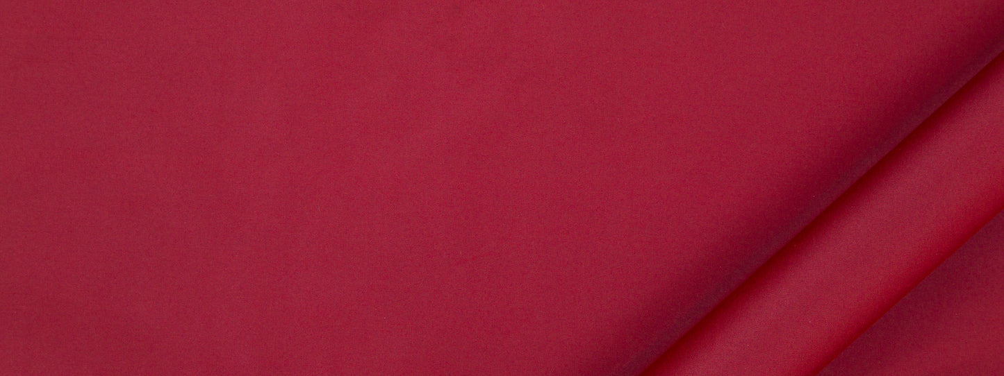 Crimson fabric with a diagonal fold and smooth matte texture; multipurpose fabric.