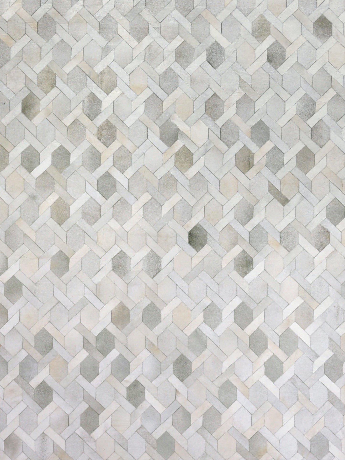 Natural hide indoor hand-stitched rug in light gray and beige tones; textured hide with subtle variation, 5' x 8'.