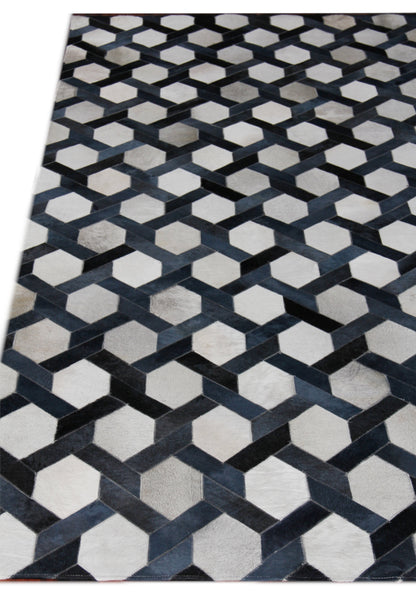 Natural hide indoor hand-stitched rug with interlocking hexagon cube design in black, gray and ivory.