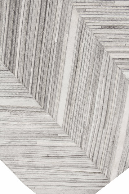 Close-up of a textured cream and gray rug with nested rectangular raised ridges forming a geometric pattern.