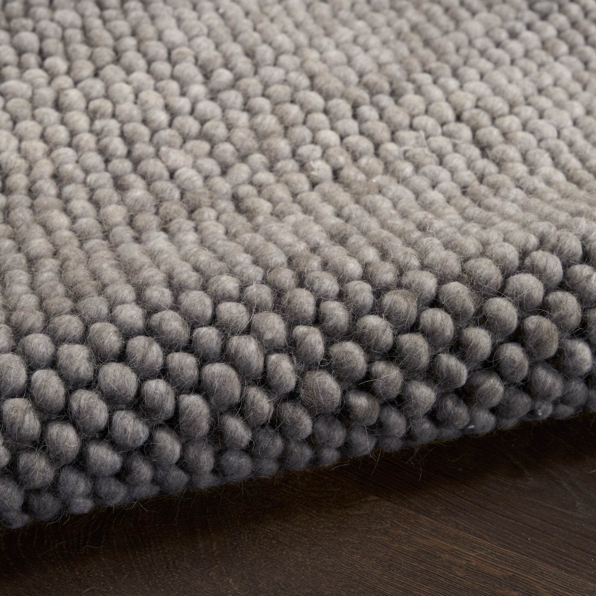 Gray boucle rug close-up with dense rounded loop fibers for a soft, modern floor accent.
