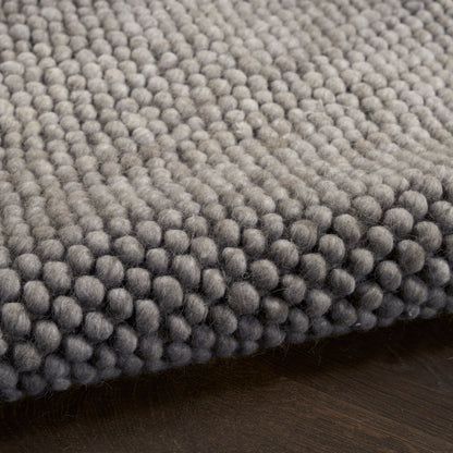 Gray boucle rug close-up with dense rounded loop fibers for a soft, modern floor accent.