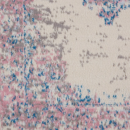 Close-up of a textured vintage runner rug with pink, blue and beige tones in an abstract distressed pattern.