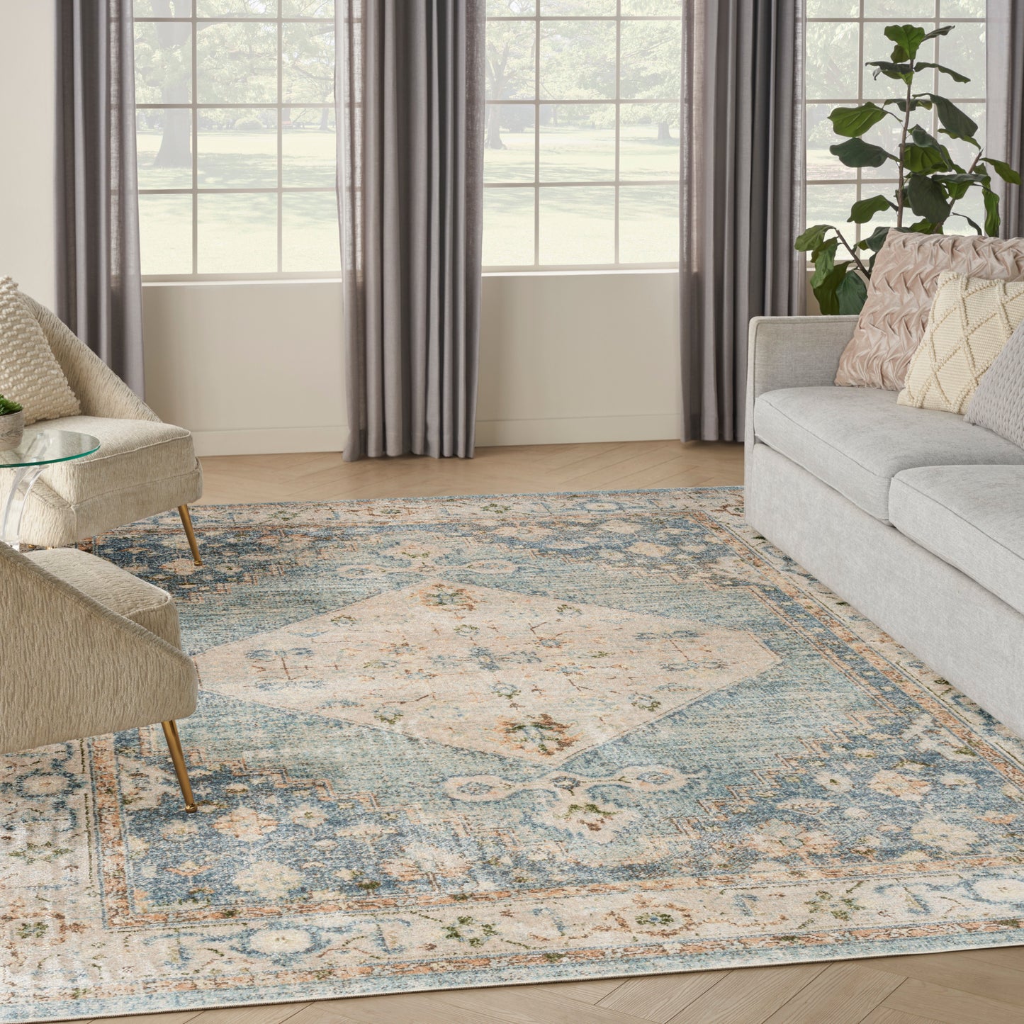 Pastel blue & cream oriental rug in a bright living room with gray & beige chairs.