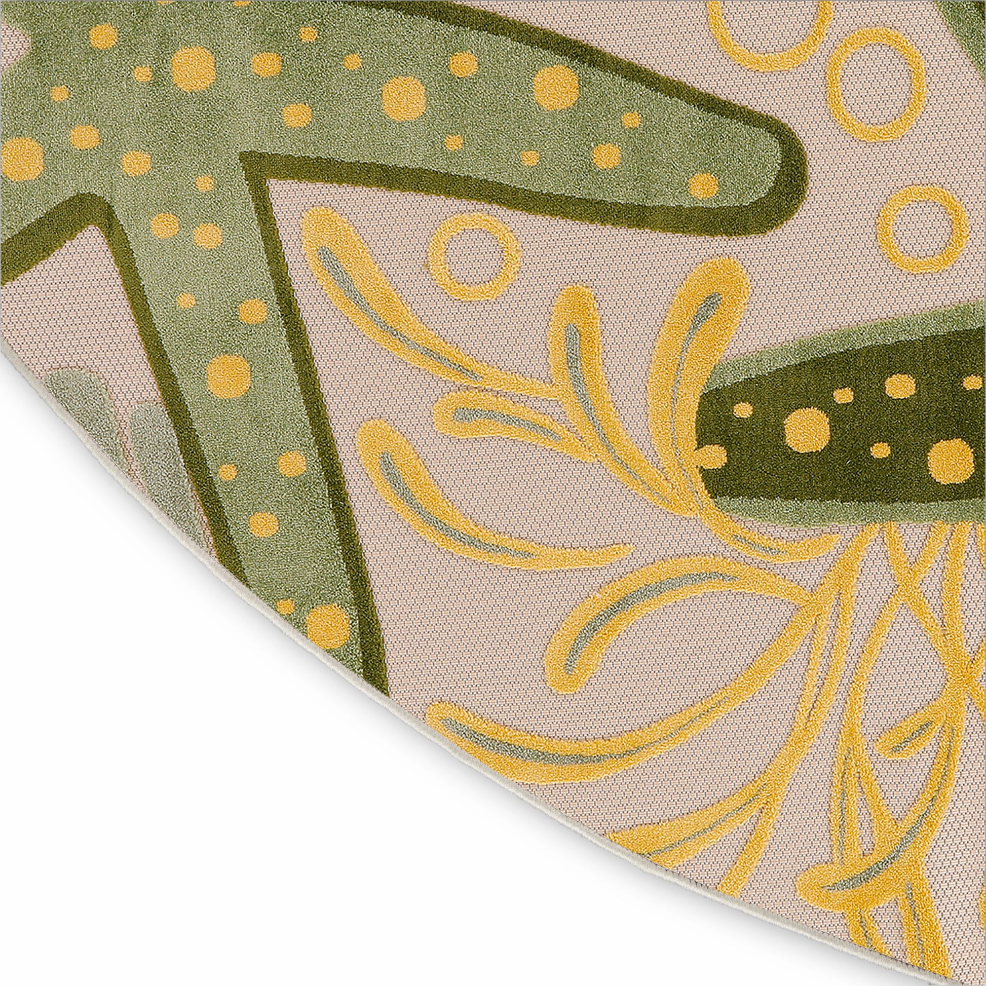 Close-up of a round beige outdoor rug with olive green leaf shapes, yellow scrolls and dotted accents.