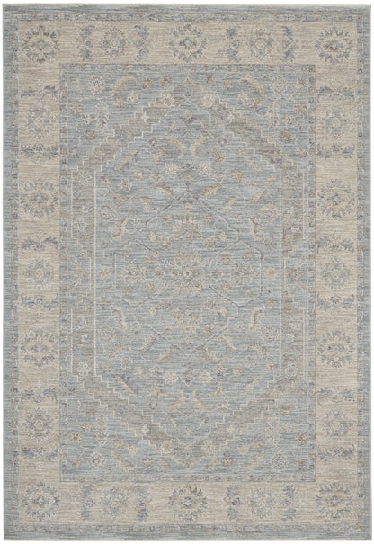 Muted blue-gray oriental rug with beige floral medallion center and ornate border, distressed vintage finish.