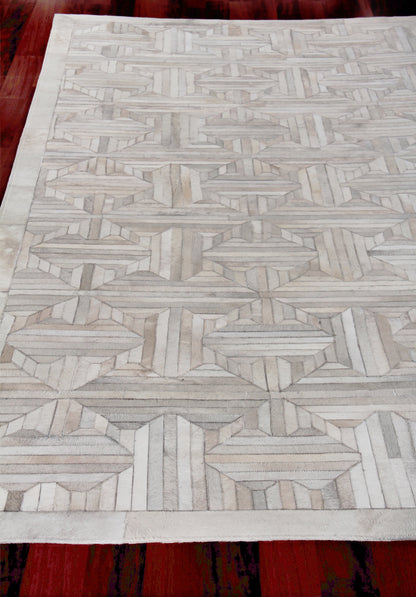 Natural hide indoor hand-stitched area rug in ivory and light gray with a geometric lattice pattern.