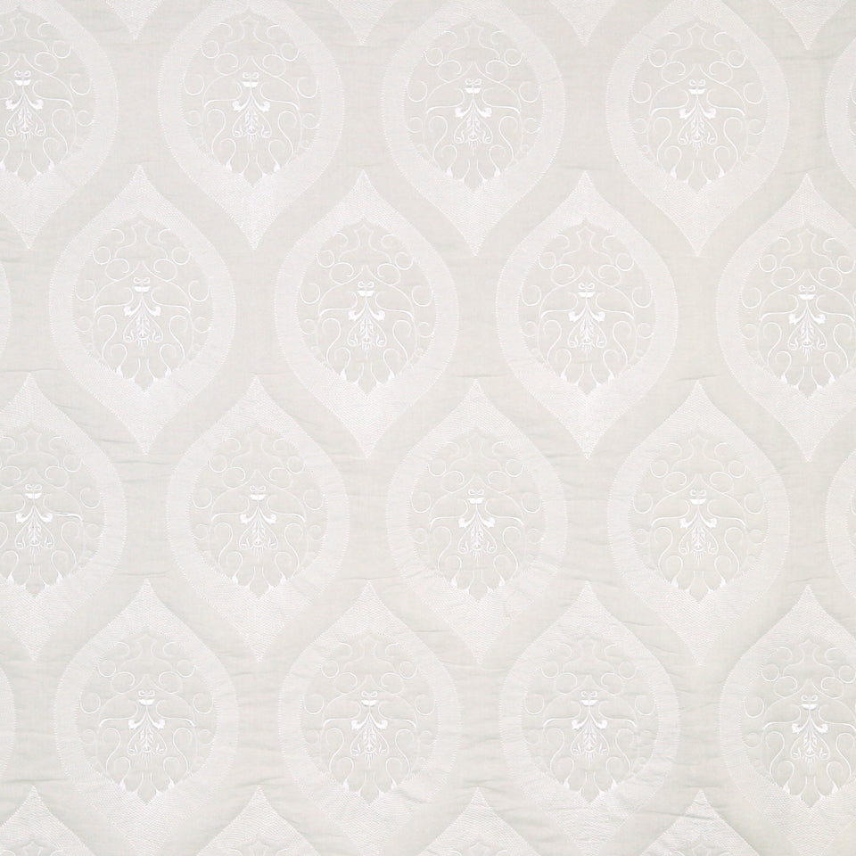 Cream damask wallpaper with repeating ivory teardrop motifs and subtle embossed floral centers; classic elegant decor.