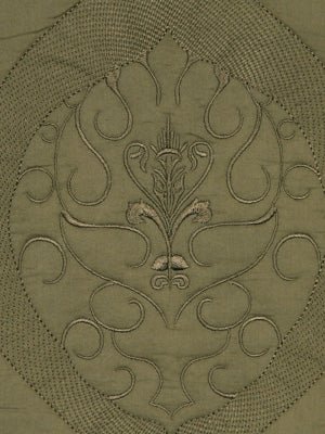 Olive green quilt block with symmetrical embroidery: central floral motif and curling vines inside an oval medallion.
