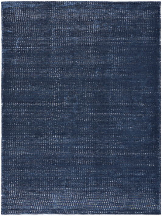 Rectangular dark indigo rug with subtle distressed weave and soft texture; versatile for living room or bedroom.