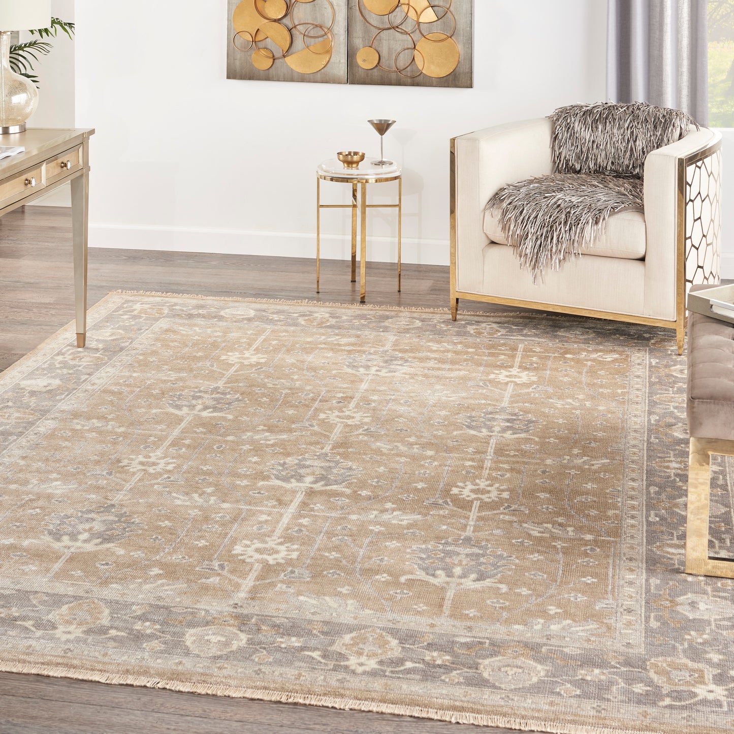 Rectangular beige vintage-style area rug with faded floral pattern and fringe.