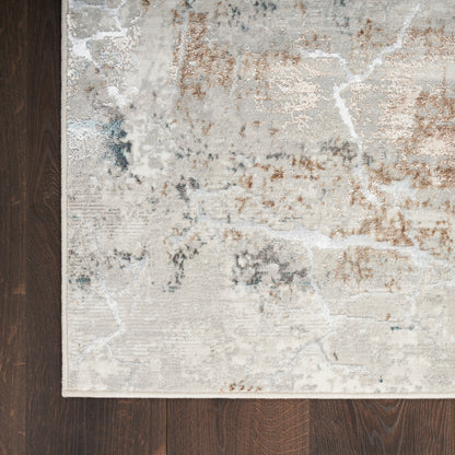 Neutral abstract area rug with cream, beige, gray and rust tones on dark wood floor; distressed pattern, soft hues.