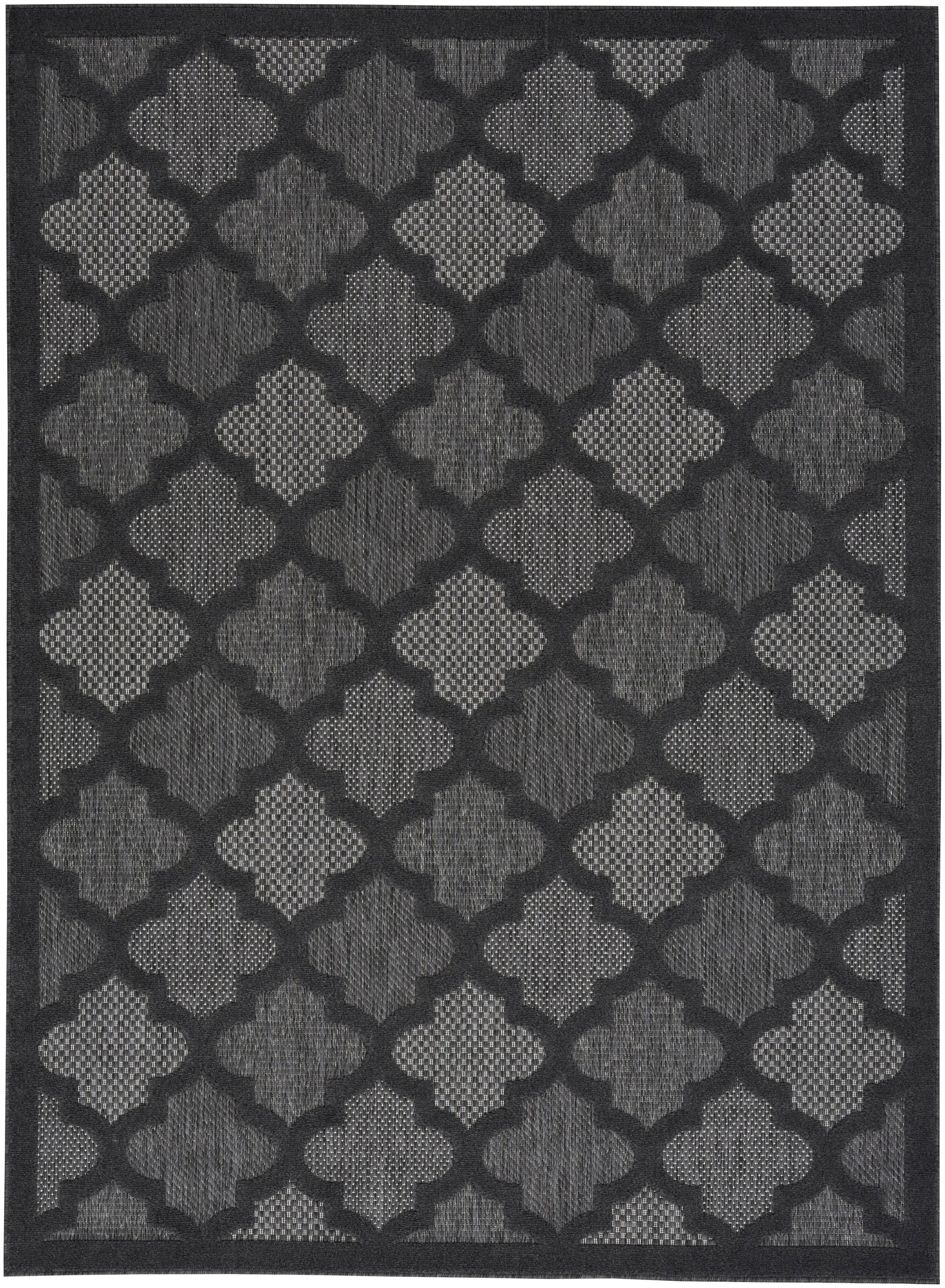 Rectangular charcoal rug with light grey quatrefoil trellis pattern and woven texture, dark border.