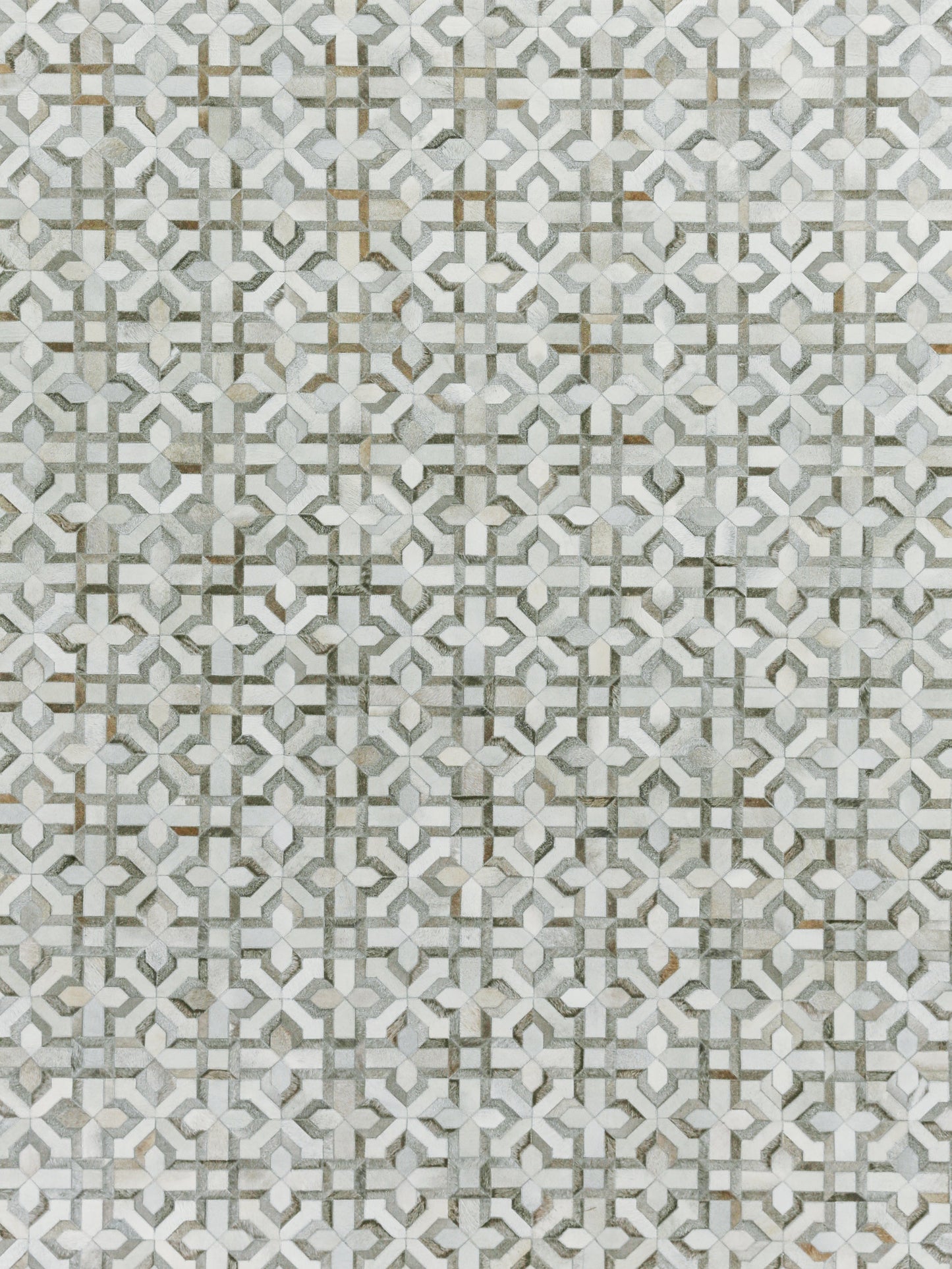 Grey and white geometric pattern on a natural hide rug with interlocking motifs and subtle gold accents; hand-stitched.
