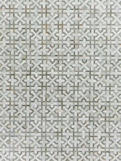 Grey and white geometric pattern on a natural hide rug with interlocking motifs and subtle gold accents; hand-stitched.