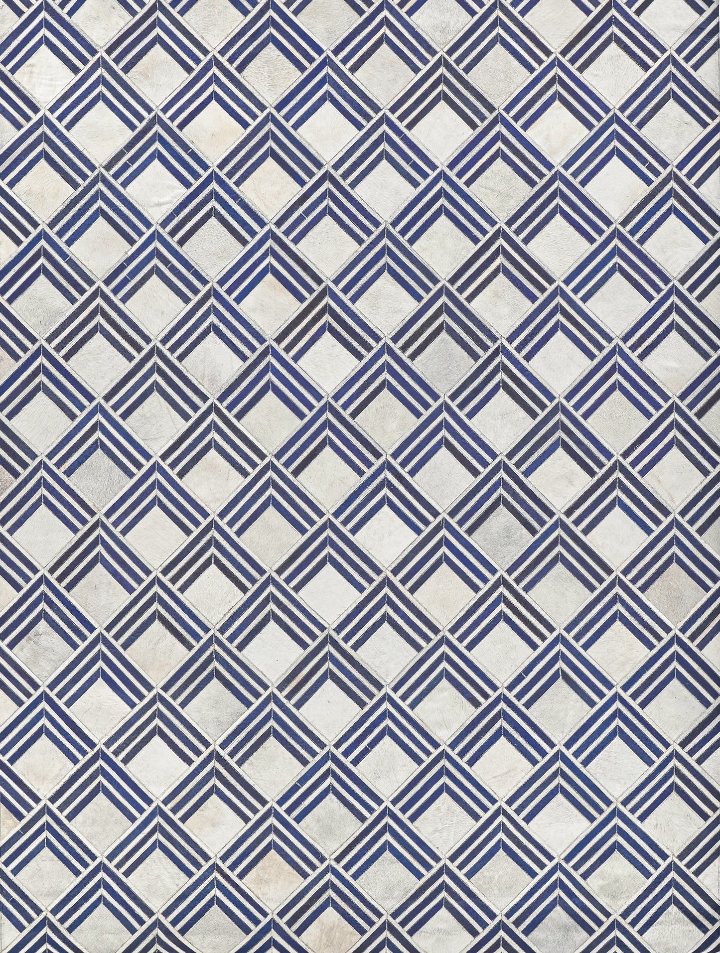 Blue and white diamond pattern on a natural hide rug; indoor hand-stitched.