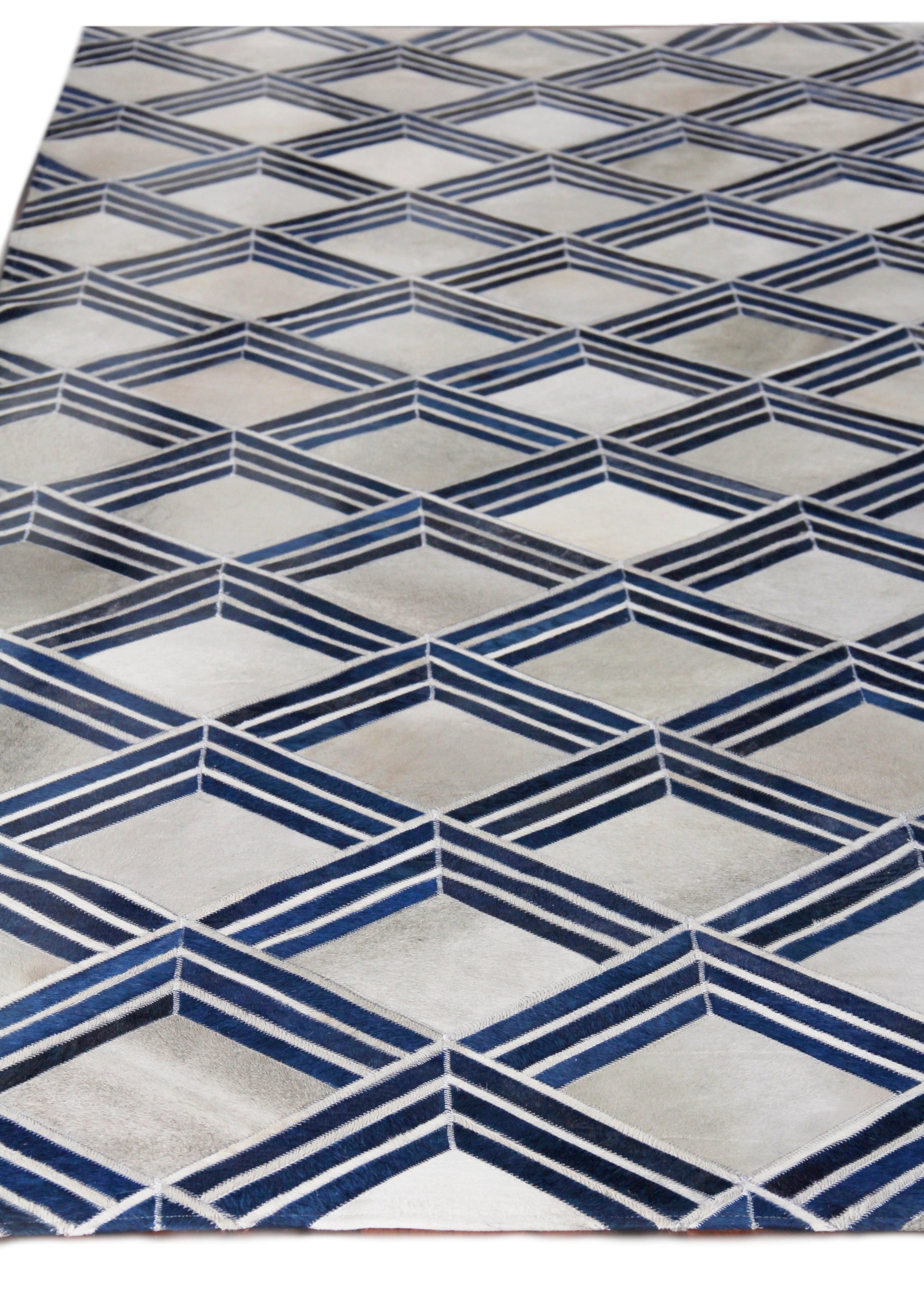 Natural hide indoor hand-stitched rug with a geometric pattern featuring navy blue chevron diamonds on a light gray background.