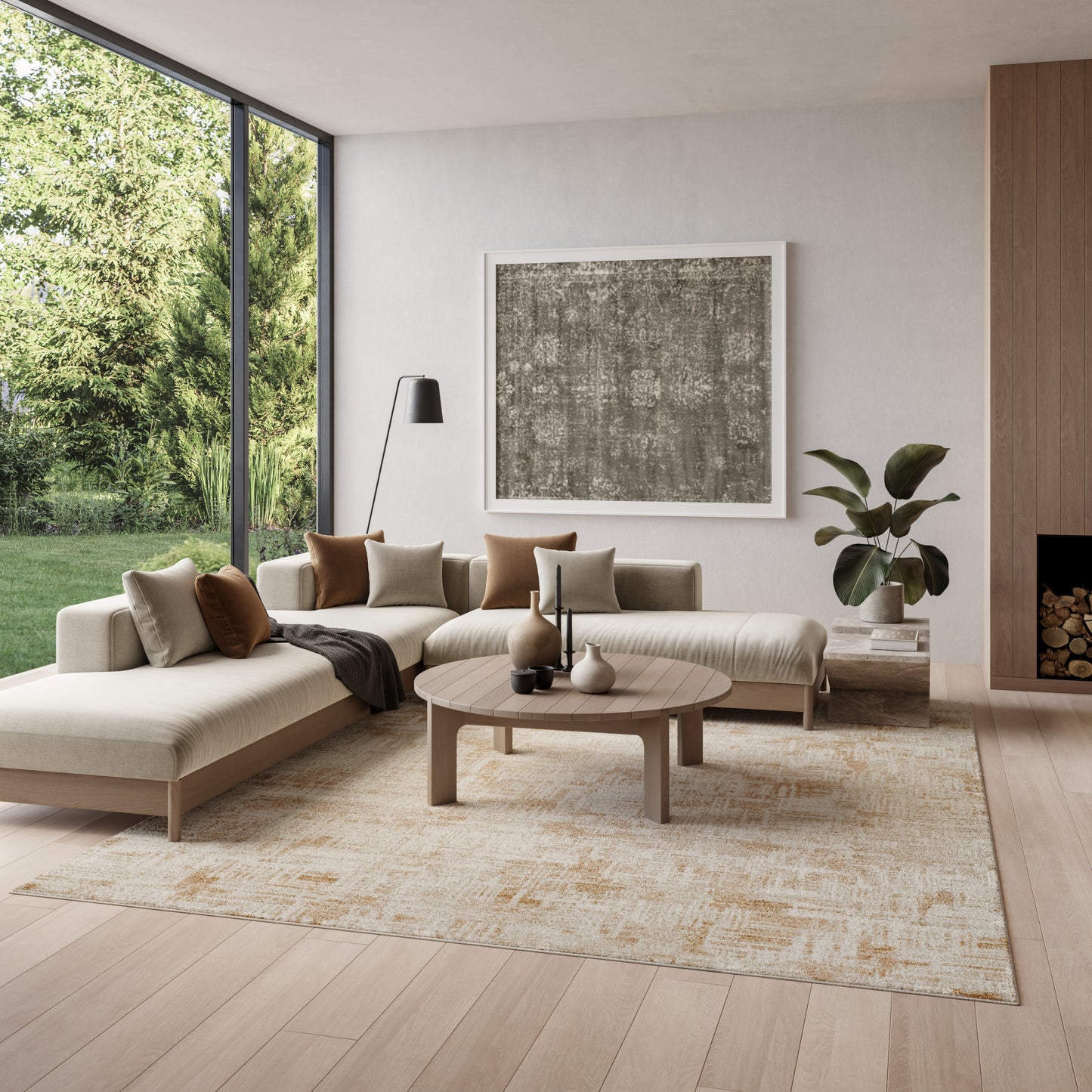 Light beige area rug on a light hardwood floor in a living room with a beige sectional sofa, neutral pillows, a round wood coffee table and large gray abstract art.