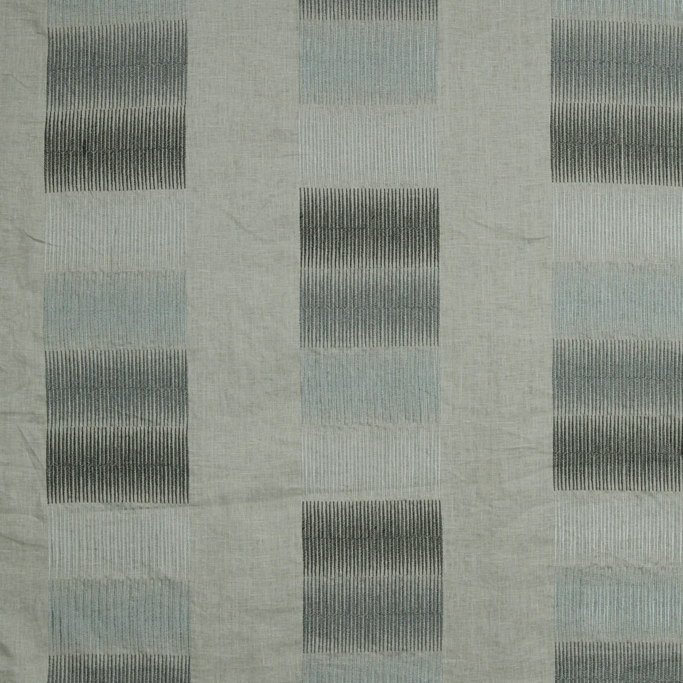 Soft gray textile with a geometric checkerboard pattern of dark vertical-striped squares on a light gray background.