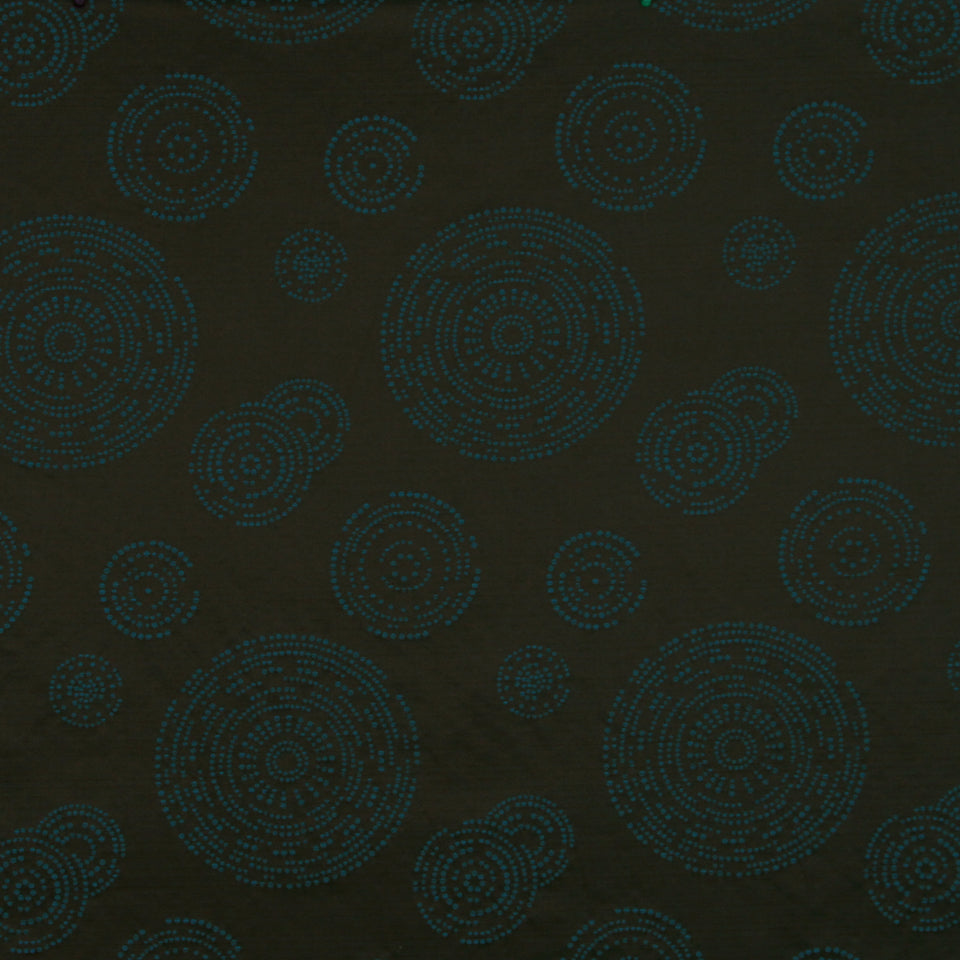 Dark brown fabric with teal dotted circular mandala patterns in varying sizes.