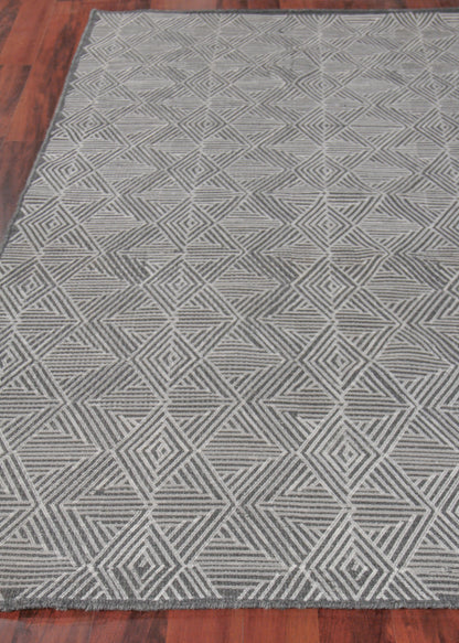 Grey geometric area rug with interlocking diamond and triangle pattern; modern neutral rectangle for living room.