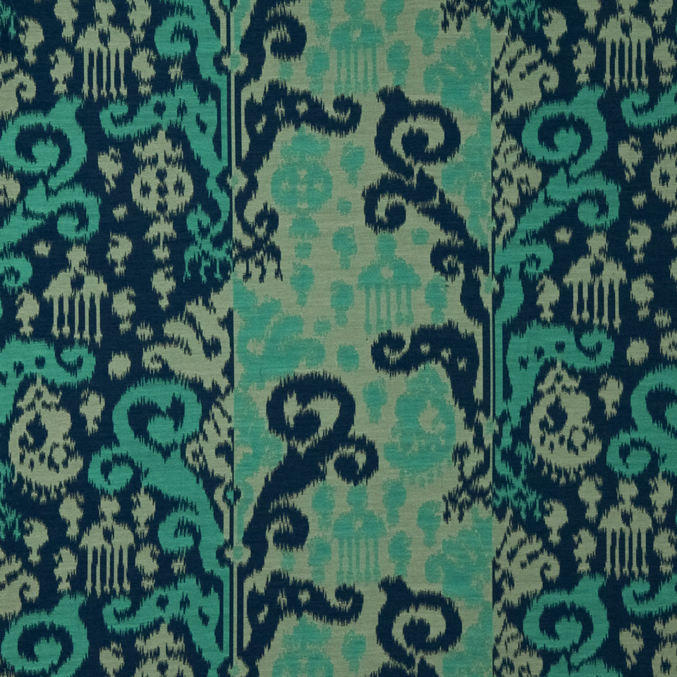 Teal, turquoise and navy Ikat patterned rectangular rug with scrolling motifs; decorative rug for living room decor.